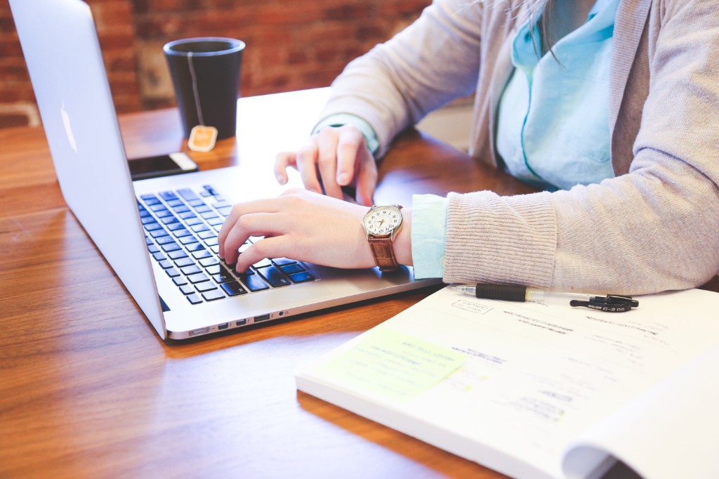Professional writer working at a desk with laptop and notebook